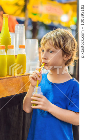 Boy drinking sugar cane juice on the Asian market 100895182