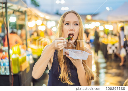 Young woman tourist on Walking street Asian food market Young woman tourist on Walking street Asian food market 100895188
