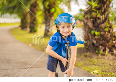 Boy riding scooters, outdoor in the park, summertime. Kids are happy playing outdoors Boy riding scooters, outdoor in the park, summertime. Kids are happy playing outdoors 100895449