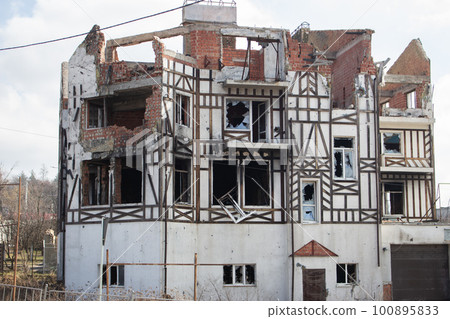Destroyed building after russian invasion, Gostomel, Ukraine. Ruined facade of house with fachwerk design. War in Ukraine. Broken windows and brick walls after missile attack. Abandoned damaged home. Destroyed building after russian invasion, Gostomel, Ukraine. Ruined facade of house with fachwerk design. War in Ukraine. Broken windows and brick walls after missile attack. Abandoned damaged home. 100895833