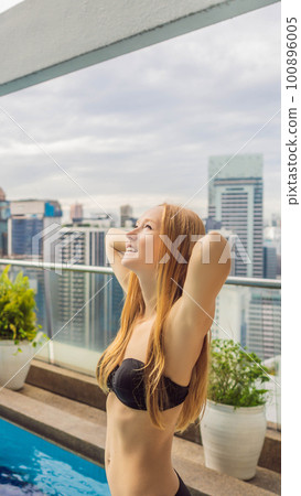 Young woman in the pool among the skyscrapers and the big city. Relax in the big city. Rest from stress BANNER, LONG FORMAT Young woman in the pool among the skyscrapers and the big city. Relax in the big city. Rest from stress BANNER, LONG FORMAT 100896005
