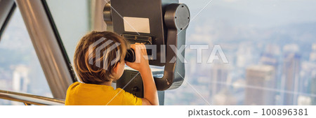 Little boy looks at Kuala lumpur cityscape. Panoramic view of Kuala Lumpur city skyline evening at sunset skyscrapers building in Malaysia. Traveling with kids concept BANNER, LONG FORMAT Little boy looks at Kuala lumpur cityscape. Panoramic view of Kuala Lumpur city skyline evening at sunset skyscrapers building in Malaysia. Traveling with kids concept BANNER, LONG FORMAT 100896381