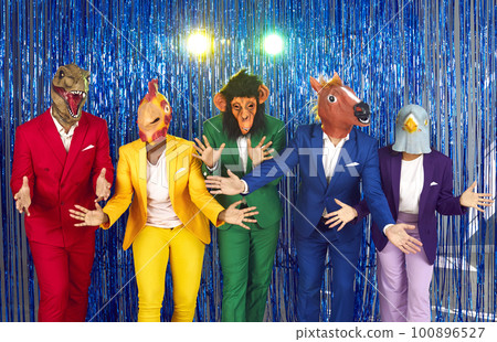 Cheerful and creative people in different animal head masks having fun together at party. 100896527