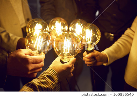Business team holding light bulbs, sharing creative energy and developing new ideas Business team holding light bulbs, sharing creative energy and developing new ideas 100896540
