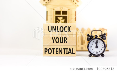 Unlock your potential symbol. Concept words Unlock your potential on wooden blocks. Black alarm clock. Beautiful white background. Business, psychological unlock your potential concept. Copy space. 100896812