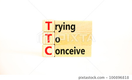 TTC trying to conceive symbol. Concept words TTC trying to conceive on wooden blocks on a beautiful white table white background. Medical and TTC trying to conceive concept. Copy space. 100896818