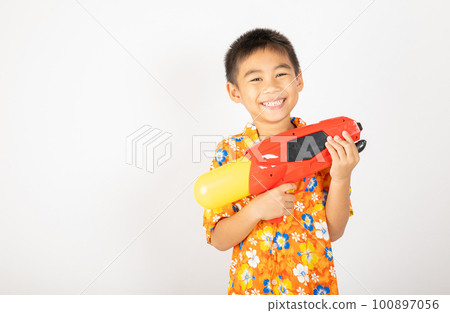 Happy Songkran Day, Asian kid boy with floral shirt hold water gun, Thai child funny hold toy water pistol and smile, isolated on white background, Thailand Songkran festival national culture concept 100897056