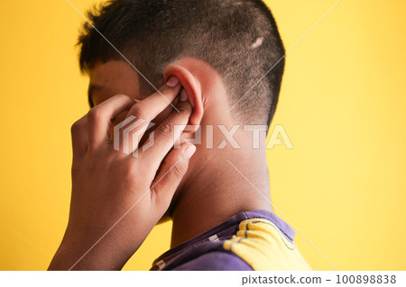 teenage boy having ear pain touching his painful ear , 100898838