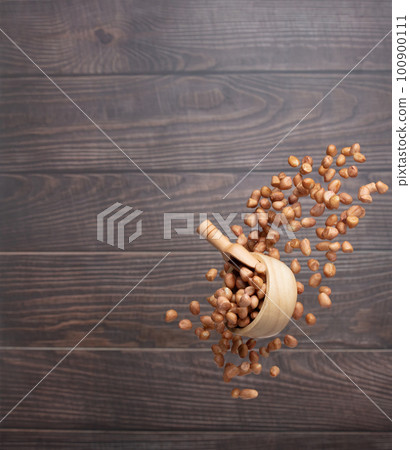 Peanut flying in wood bowl, brown grain peanuts throw abstract float. Beautiful complete seed pea peanut bowl splash in air, food object design. Wooden background high speed shutter freeze shot Peanut flying in wood bowl, brown grain peanuts throw abstract float. Beautiful complete seed pea peanut bowl splash in air, food object design. Wooden background high speed shutter freeze shot 100900111