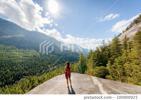 Hiking woman reaching amazing viewpoint on famous Squamish Stawamus Chief Mountain Hike in British Columbia nature landscape. Popular outdoor activity destination in Canada Hiking woman reaching amazing viewpoint on famous Squamish Stawamus Chief Mountain Hike in British Columbia nature landscape. Popular outdoor activity destination in Canada 100900925