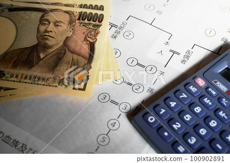 一張 10,000 日元的鈔票和一個放在相關圖表上的計算器,繼承的圖像 一張 10,000 日元的鈔票和一個放在相關圖表上的計算器,繼承的圖像 100902891