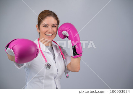 Woman doctor in pink boxing gloves on a white background. 100903924