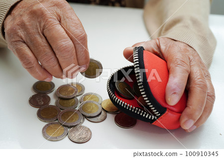 Retired elderly woman counting coins money and worry about monthly expenses and treatment fee payment. Retired elderly woman counting coins money and worry about monthly expenses and treatment fee payment. 100910345