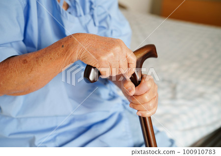 Asian elderly disability woman patient holding walking stick in wrinkled hand at hospital. Asian elderly disability woman patient holding walking stick in wrinkled hand at hospital. 100910783