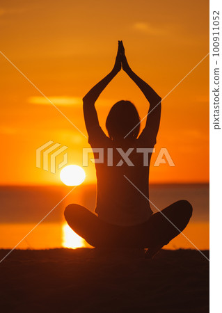 yoga meditation, silhouette of woman at sunset in lotus position. health recreation and sports yoga meditation, silhouette of woman at sunset in lotus position. health recreation and sports 100911052