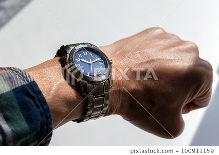 watch worn on a man's wrist watch worn on a man's wrist 100911159