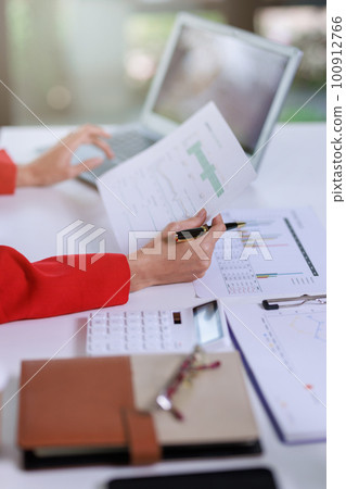 Concept of business office woman working,Closeup businesswoman checking her invesment plan with analyzing document and business investment graph data by using calculator and laptop 100912766