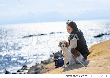 Koikerhondje and her owner on the lawn with the ocean in the background 100913551