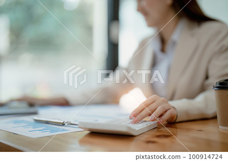 business owner or Asian female marketers are using calculator to calculate and tablet computer in office work. 100914724