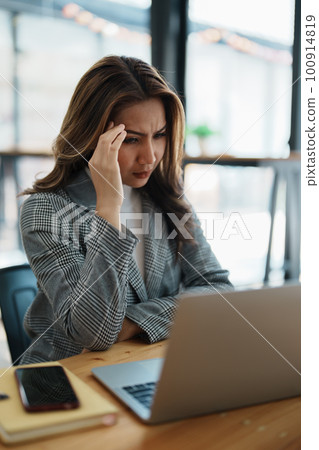 Portrait of business owner, woman using computer and financial statements Anxious expression on expanding the market to increase the ability to invest in business. Portrait of business owner, woman using computer and financial statements Anxious expression on expanding the market to increase the ability to invest in business. 100914819