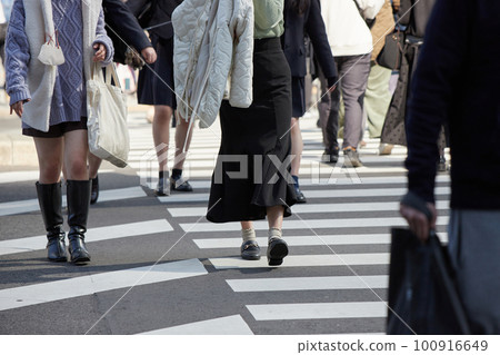 Footsteps of people crossing a pedestrian crossing at an urban intersection 100916649