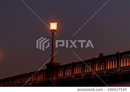 Streetlights shining on the bridge at night 100917545