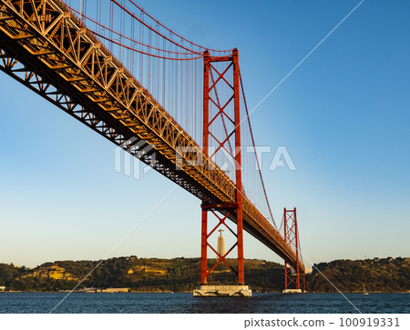 Impressive view of the 25 de Abril (25th April) suspension bridge crossing the Tagus river, Belem district, Lisbon, Portugal 100919331