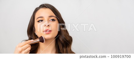 Beauty woman with cosmetic brush for natural makeup on the grey background with copy space.  100919700