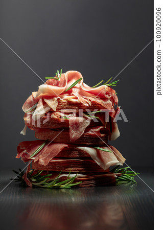 Italian prosciutto or Spanish jamon with bread and rosemary. Italian prosciutto or Spanish jamon with bread and rosemary. 100920096