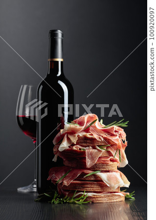 Spanish jamon or Italian prosciutto with bread, rosemary, and red wine. Spanish jamon or Italian prosciutto with bread, rosemary, and red wine. 100920097