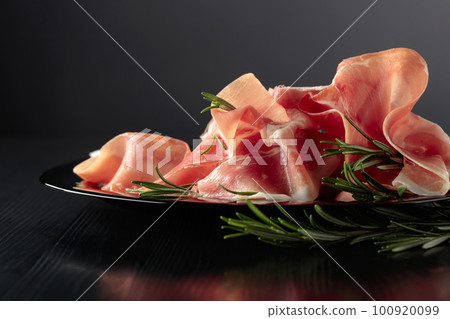Italian prosciutto or Spanish jamon with rosemary. Italian prosciutto or Spanish jamon with rosemary. 100920099