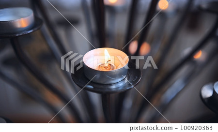 Candlestick holder with burning candles in a Catholic church. 100920363