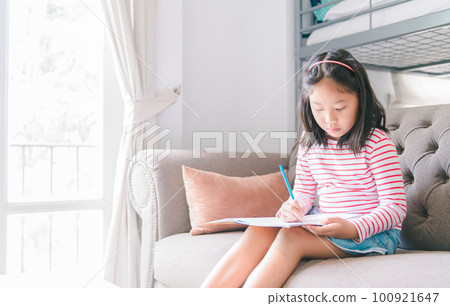 cute girl paint or do homework on sofa in living room, learn and relax cute girl paint or do homework on sofa in living room, learn and relax 100921647