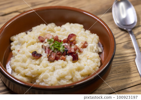 Slovakian halusky served with sheep cheese and roasted bacon 100923197