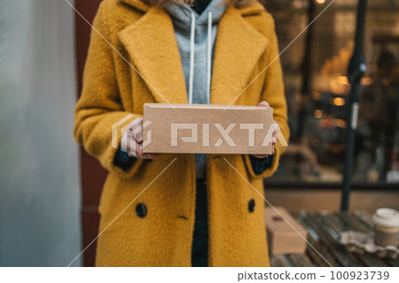 Young caucasian woman with parcel at city street. Young caucasian woman with parcel at city street. 100923739
