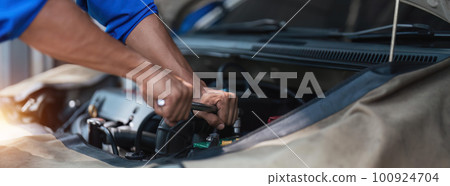 Close up technician uses multimeter voltmeter to check voltage level in car battery. Service and Maintenance car battery. 100924704