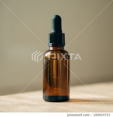 Amber glass serum oil dropper bottle on wooden table mock-up, cosmetic container daylight shot Amber glass serum oil dropper bottle on wooden table mock-up, cosmetic container daylight shot 100924731