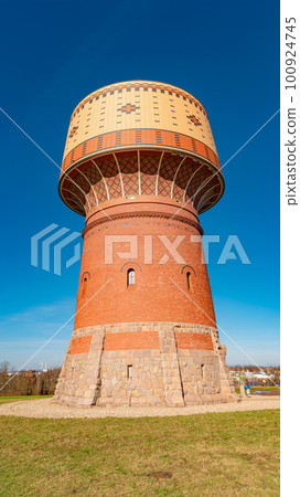 View over a very old water collecting tower in a small town Mittweida, Germany, at sunny day and blue sky. View over a very old water collecting tower in a small town Mittweida, Germany, at sunny day and blue sky. 100924745