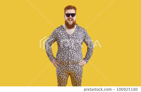 Portrait of funny comic fat man in leopard pajamas who laughs out loud on orange background. 100925180
