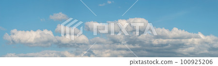 Banner with panoramic view over deep blue clean sky with illuminated clouds as a background. 100925206