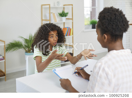 Amazed african american teen girl is talking with school psychologist about her problems. Amazed african american teen girl is talking with school psychologist about her problems. 100925208