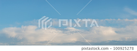 Panoramic view over soft blue sky with illuminated by sun rainy clouds as a background banner. 100925278