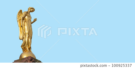 Banner with a beautiful golden angel column statue at Market Square in small town Mittweida, its historical downtown, Saxony, Germany, at blue sky solid background with copy space. 100925337