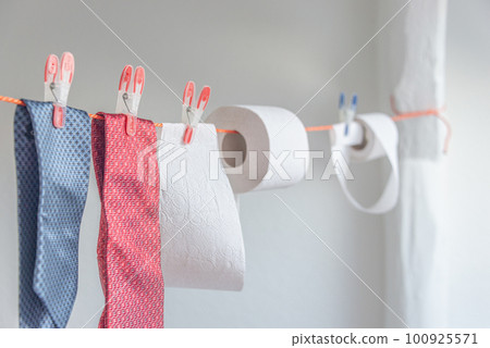 Toilet paper rolls hanging on clothesline for drying and reuse and washing together with expensive ties.. Concept of economical, financial crisis. Toilet paper rolls hanging on clothesline for drying and reuse and washing together with expensive ties.. Concept of economical, financial crisis. 100925571