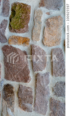 Panoramic view over a long middle age stone wall with patterns of ancient bricks and stones as a background, closeup, details. 100925597