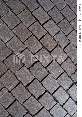 Pattern of ancient bricks and stones at old middle age pavement, as a background, closeup, details. 100925664