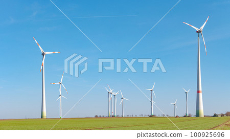 Panoramic view over beautiful farm landscape with early spring agriculture field, wind turbines to produce green energy near Mittweida, Germany, at blue sunny sky. 100925696