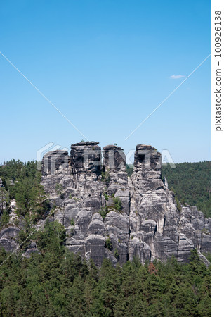 Monumental Bastei sandstone pillars and rock formation near Kurort Rathen village in the national park Saxon Switzerland by Dresden and Czechish border, Saxony, Germany. Monumental Bastei sandstone pillars and rock formation near Kurort Rathen village in the national park Saxon Switzerland by Dresden and Czechish border, Saxony, Germany. 100926138