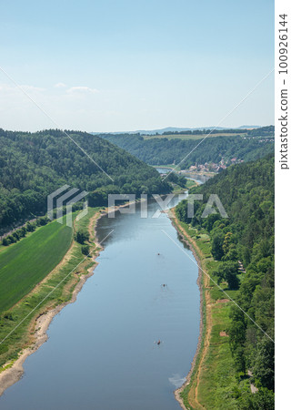 Cover page with birdview over monumental Bastei sandstone pillars near Kurort Rathen village in the national park Saxon Switzerland by Dresden and Elbe river with blue sky, Saxony, Germany. 100926144