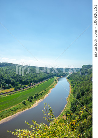 Cover page with birdview over monumental Bastei sandstone pillars near Kurort Rathen village in the national park Saxon Switzerland by Dresden and Elbe river with blue sky, Saxony, Germany. 100926153